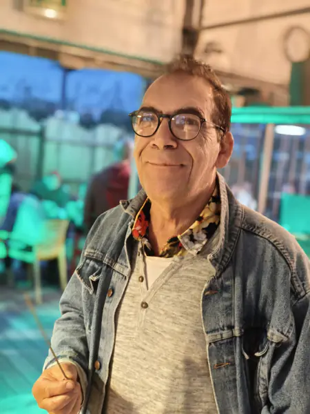 Un habitué sur la terrasse éclairée en vert, un soir de match